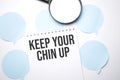 White noteapad and magnifier on blue speech bubles. Text Keep your chin up. Business concept Royalty Free Stock Photo