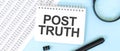 White noteapad and magnifier on the financial documentation. Text POST TRUTH. Business concept Royalty Free Stock Photo