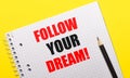 White notebook with inscription FOLLOW YOUR DREAM written in black pencil on a bright yellow background