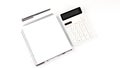 White notebook with a pencil ,pen and a calculator on a white background Royalty Free Stock Photo