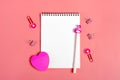 White notepad, clips, pen in the shape of a flamingo on a pink background Royalty Free Stock Photo