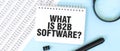 White notepad and magnifier on the financial documentation. Text WHAT IS B2B SOFTWARE. Business concept Royalty Free Stock Photo