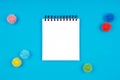 White notepad with plastic balls as viruses on the blue background with isolated white place for text. Epidemic