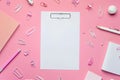 white notepad sheet on a pink background. Back to school, school supplies, top view