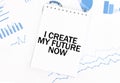 White notepad with text I CREATE MY FUTURE NOW on the financial documentation. Finance and business concept Royalty Free Stock Photo
