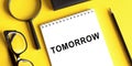 White notepad with text TOMORROW. Beautiful yeloow background. Business concept Royalty Free Stock Photo