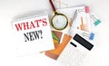 White notepad text WHAT`S NEW with diagram,chart,calculator on the white background Royalty Free Stock Photo