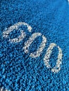 White 600 number on blue tartan running track