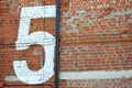 White number five painted on a red brick wall. Number 5 Royalty Free Stock Photo