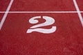 A white number 2 on a starting line of a running track field. Royalty Free Stock Photo