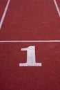 A white number 1 on a starting line of a running track field. Royalty Free Stock Photo