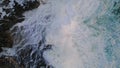White ocean foam splashing on stone coast aerial view. Stormy foaming waves. Royalty Free Stock Photo