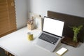 White office desk with laptop computer, coffee cup, smart phone, houseplant and pencils holder. Royalty Free Stock Photo