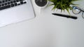 White office desk with laptop, coffee cup, eyeglasses, pen house plant and copy space. Royalty Free Stock Photo