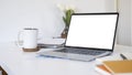 White office desk with laptop computer, document, notebook and coffee cup. Empty screen for your advertise text Royalty Free Stock Photo