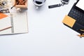White office desk with laptop, cup of coffee, notepad and stationery. Top view with space for text Royalty Free Stock Photo