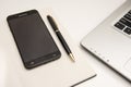 White office desk with a notebook Pen and laptop computer Royalty Free Stock Photo