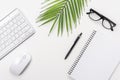 White office desk table with blank notebook, computer keyboard and other office supplies. Top view with copy space Royalty Free Stock Photo