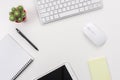 White office desk table with blank notebook, computer keyboard and other office supplies. Top view with copy space Royalty Free Stock Photo