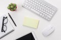 White office desk table with blank notebook, computer keyboard and other office supplies. Top view with copy space Royalty Free Stock Photo