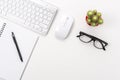 White office desk table with blank notebook, computer keyboard and other office supplies. Top view with copy space Royalty Free Stock Photo