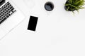 White office desk table with laptop computer, smartphone, cup of coffee and supplies. Top view with copy space, flat lay Royalty Free Stock Photo