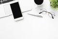 White office desk table with smartphone with blank mock up screen, laptop computer and supplies. Top view with copy space, flat Royalty Free Stock Photo