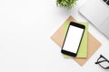 White office desk table with smartphone with blank screen and other office supplies. Top view with copy space, flat lay Royalty Free Stock Photo