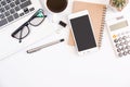 White office desk table, workspace office with laptop, smartphone black screen, coffee cup,pen,calculator, glasses, Top view with Royalty Free Stock Photo