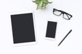 White office desk with tablet, smartphone, glasses and pen. Blank mobile phone and notepad for input text. Business, finance Royalty Free Stock Photo