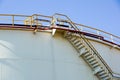 White oil or chemical tanks with spiral staircase.Stairs to the top of an oil or chemical tank .Staircase on big fuel Royalty Free Stock Photo