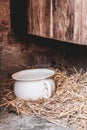 White old chamber pot in straw outside a privy