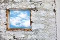 White old stone wall with blue sky and clouds window.