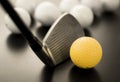 white and one yellow golf balls on black floor. individuality an