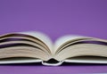 White open book  isolated on purple background Royalty Free Stock Photo