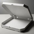 A white, open pizza box made of corrugated cardboard, placed on a flat gray surface. Royalty Free Stock Photo