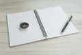 White opening blank paper note book with pen on the right and navigation compass on light grey wooden table background with copy Royalty Free Stock Photo