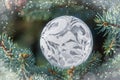 White openwork transparent Christmas bauble on spruce branches