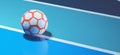 White orange futsal ball on blue indoor soccer field concept background