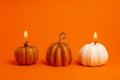 White and orange lighted decorative pumpkin candles on orange background