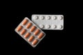 White and orange pills in a package on a black background Royalty Free Stock Photo