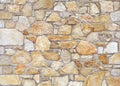 White and orange stone wall made of large flat natural rocks.