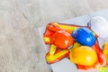 white, orange, yellow and blue hard safety helmet hat with construction worker safety clothing for safety project of workman as e Royalty Free Stock Photo