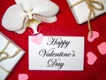 White orchid and gift box on a red background, Valentines Day background. Small paper hearts. Royalty Free Stock Photo