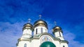 White orthodox church against the blue sky.Three domes with crosses. Golden domes of the church , ancient Christian monastery. Royalty Free Stock Photo