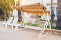 White outdoor furniture. Lounge chairs in hotel garden invite you to relax Royalty Free Stock Photo