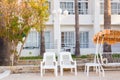 White outdoor furniture. Lounge chairs in hotel garden invite you to relax Royalty Free Stock Photo