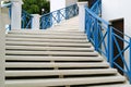 White outdoors staircase with blue railing leads to the upstairs