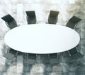 White oval conference table with black leather chairs on concrete floor Royalty Free Stock Photo