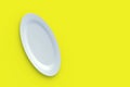 White oval plate on yellow background. Top view. Copy space